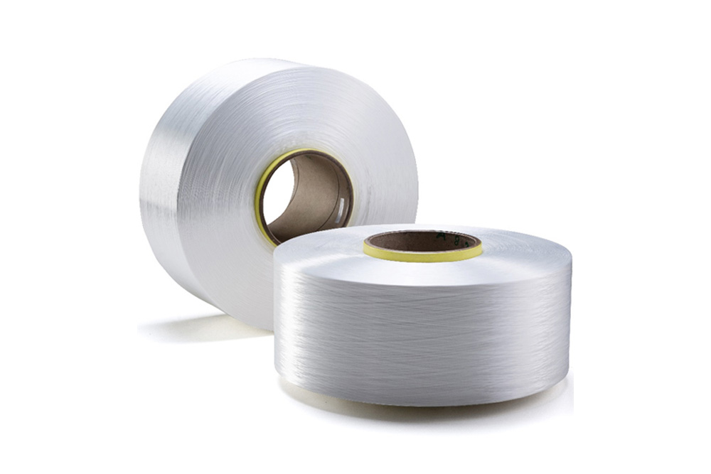 Two rolls of white yarn thread with yellow and white core caps on a white background, clean product shot